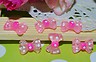 ORECCHINI A FORMA DI FIOCCHETTO ROSA E BOLLINI BIANCHI